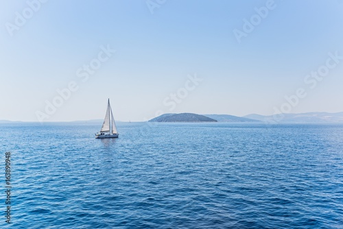 Small sailboat sailing in the calm waters © Daniel Jędzura