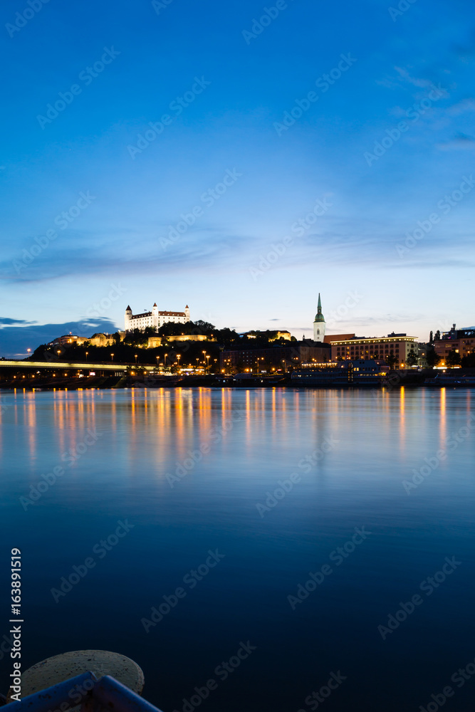 Bratislava, New Bridge, Castle, Cathedral during dusk from a boat on river Danube