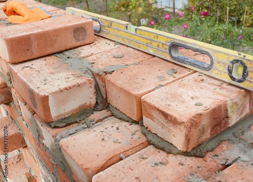 Bricklaying on House Construction Site with Spirit Level.