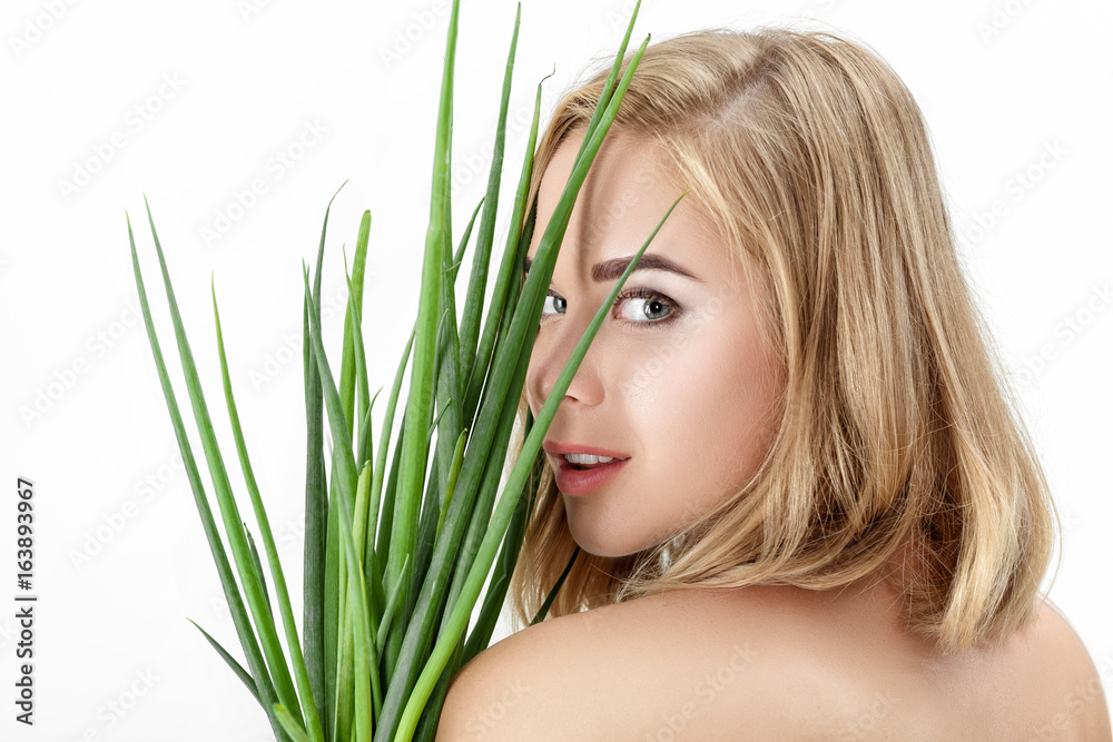 Naklejka premium Portrait of Beautiful blond woman holding green onion on white background. Health and vitamins