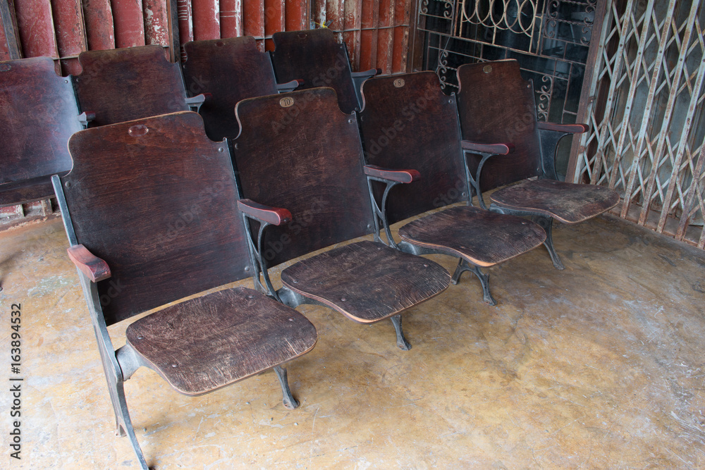 Row of vintage wooden folding seating. Armchair folding seat in cinema be placed outside the