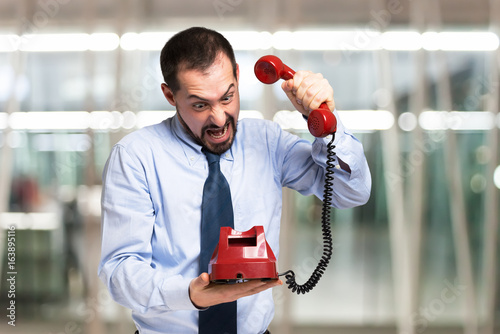 Angry man slamming the phone down photo