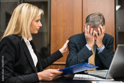 Secretary comforting her depressed and sad boss