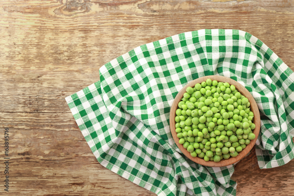 Bowl with fresh green peas on wooden table Bowl with fresh green peas on wooden table