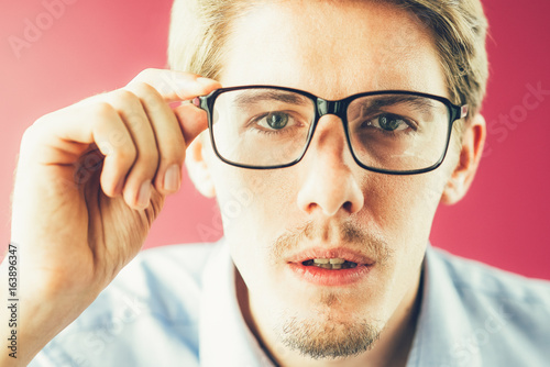 Surprised businessman staring through glasses