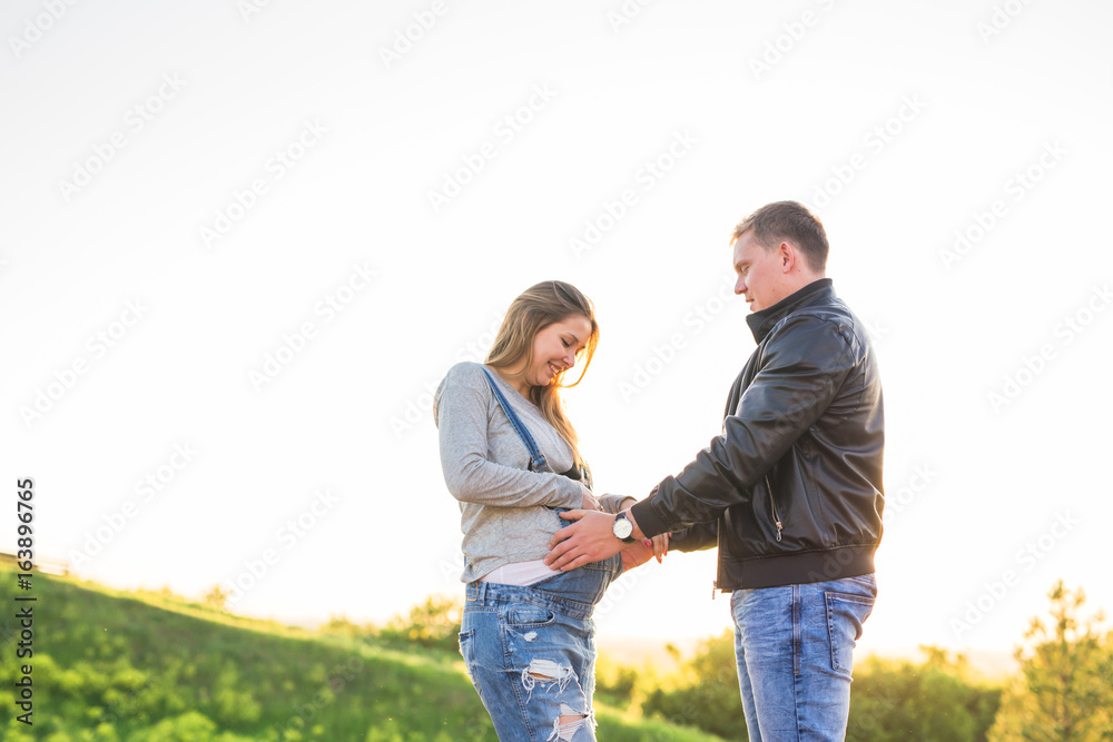 Pregnant woman with husband in nature Pregnant woman with husband in nature