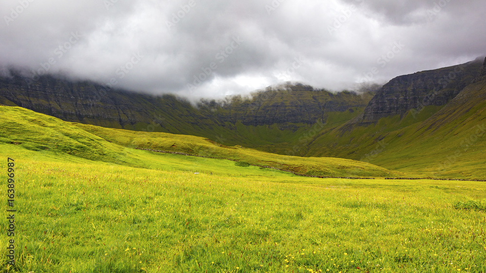 Green grass and mountains a cloudy day at Faroe Islands