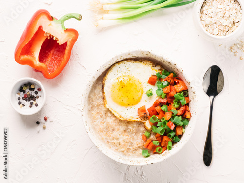 Savory oatmeal, served with vegetables and fried egg
