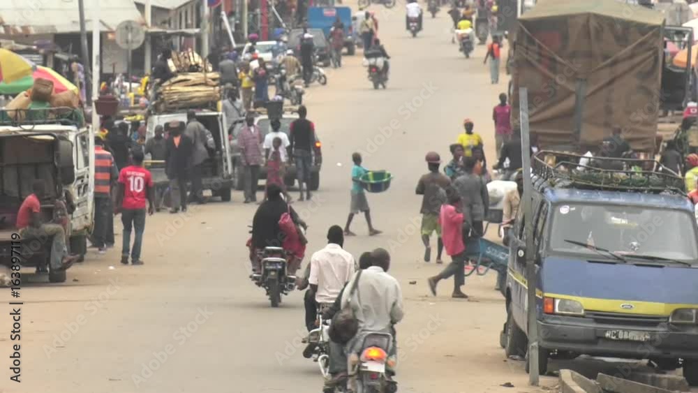 Market village town centre in Guinea West Africa with traffic and people walking Market village town centre in Guinea West Africa with traffic and people walking