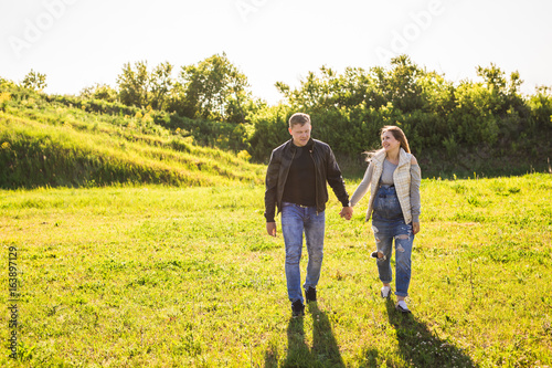 Pregnant woman with husband walking in nature