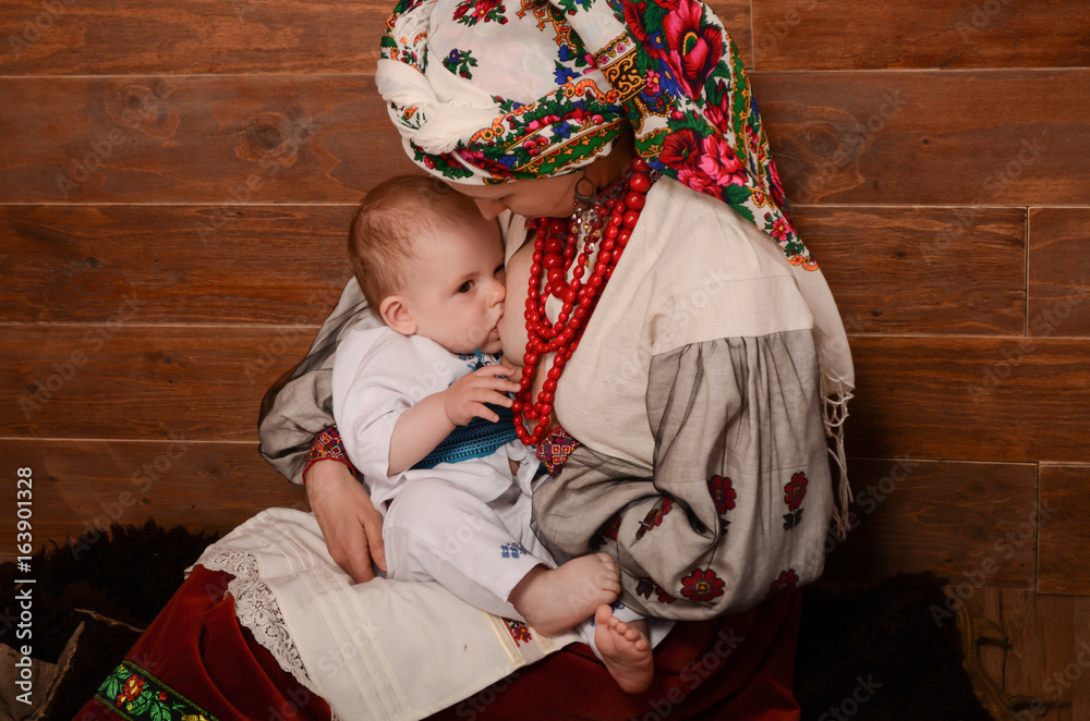 Ukrainian mother breastfeeding and hugging her baby.