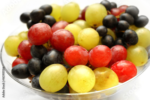 Bright assortment tasty ripe grapes in a glass plate