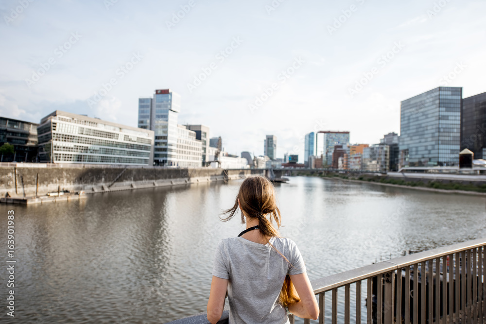 Young woman enjoying great view on the harbor with modern buildings in Dusseldorf city, Germany