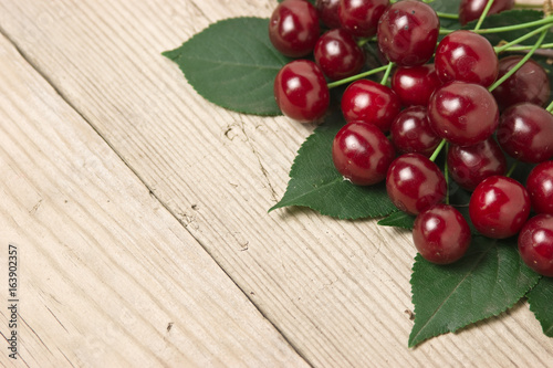 Berry Cherry with leaves on wooden background