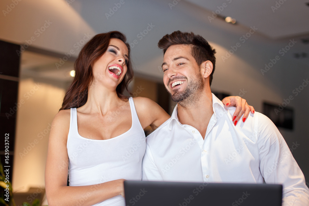Happy young couple laughing at home Happy young couple laughing at home