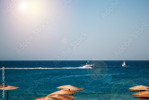 Sea panorama  overlooking the blue sea and beach with a yellow sun beds and umbrellas. Rhodes Town  Greece