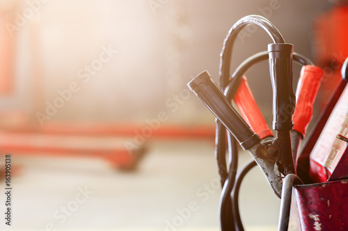 closeup battery charger in car repair center with soft-focus and over light in the background photo