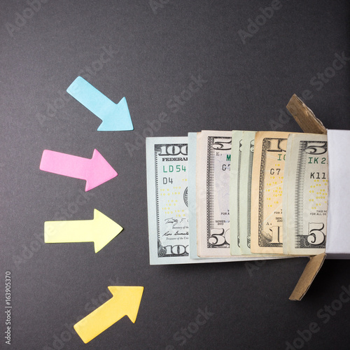 Arrows point to a stack of dollar bills looking out of the box. Increase in savings. Home safe. Business concept. photo