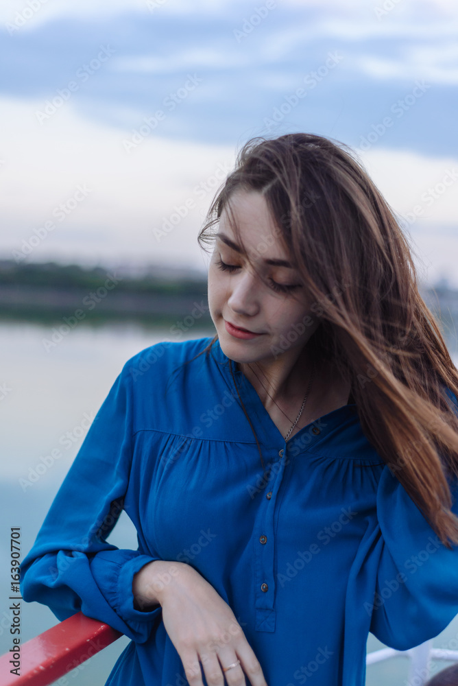 Summer happy portrait beautiful woman girl caucasian asian blended in blue shirt posing on background sky lake water sunset long hair brunette outdoors Summer happy portrait beautiful woman girl caucasian asian blended in blue shirt posing on background sky lake water sunset long hair brunette outdoors