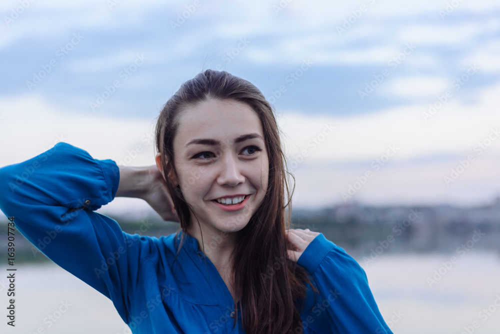 Summer happy portrait beautiful woman girl caucasian asian blended in blue shirt posing on background sky lake water sunset long hair brunette outdoors Summer happy portrait beautiful woman girl caucasian asian blended in blue shirt posing on background sky lake water sunset long hair brunette outdoors