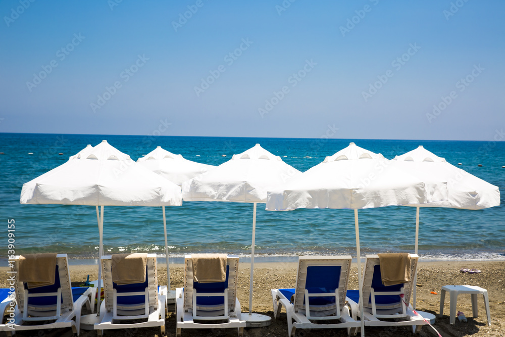 beach chairs and umbrellas on sand beach