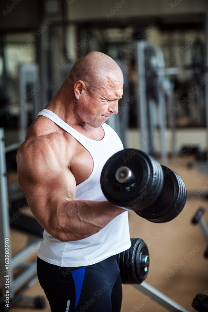 Bodybuilder deals with dumbbells Bodybuilder deals with dumbbells