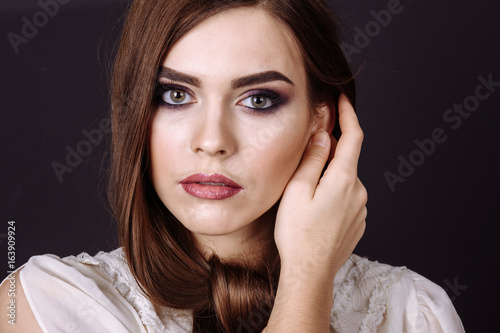 Studio portrait of a beautiful young woman with brown hair. Pretty model girl with perfect fresh clean skin. Beauty and skin care concept