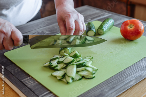 Woman cutting cucumber