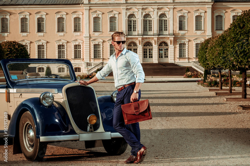 Принти на полотні Confident wealthy young man with briefcase near classic convertible