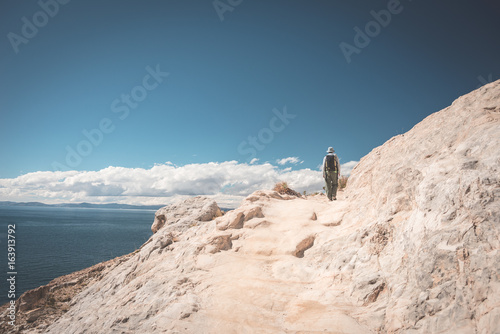 Backpacker exploring the inca s majestic footpaths on Island of the Sun  Titicaca Lake  scenic travel destination in Bolivia. Travel adventures and vacations in the Americas. Toned image.