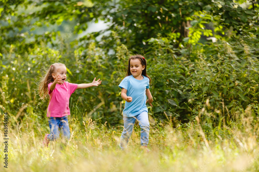 Two little ones running around holding hands in the park Two little ones running around holding hands in the park