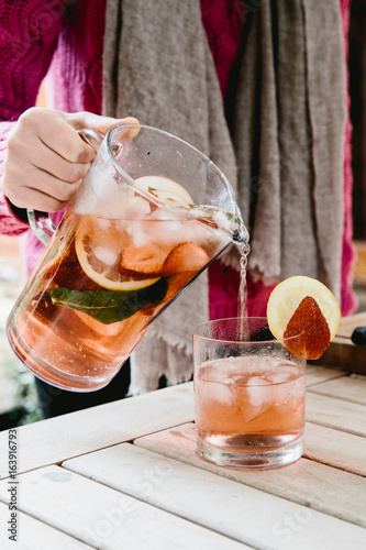 Girl pouring jug of fruity drink into a glass