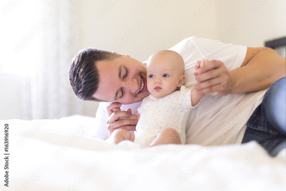 Portrait of father with her 3 month old baby in bedroom