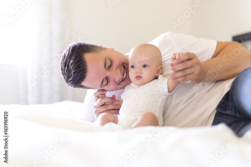 Portrait of father with her 3 month old baby in bedroom