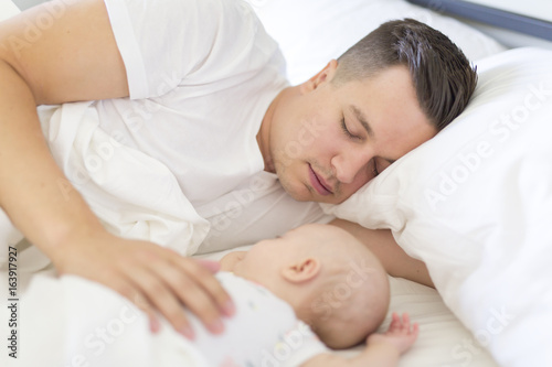 Portrait of father with her 3 month old baby in bedroom sleeping