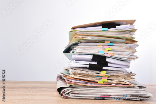 Stack documents pace on wood desk in office
