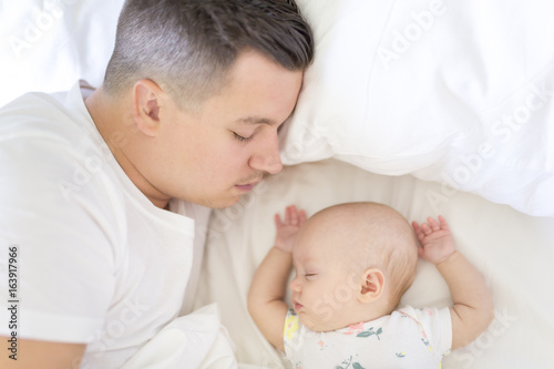 Portrait of father with her 3 month old baby in bedroom sleeping
