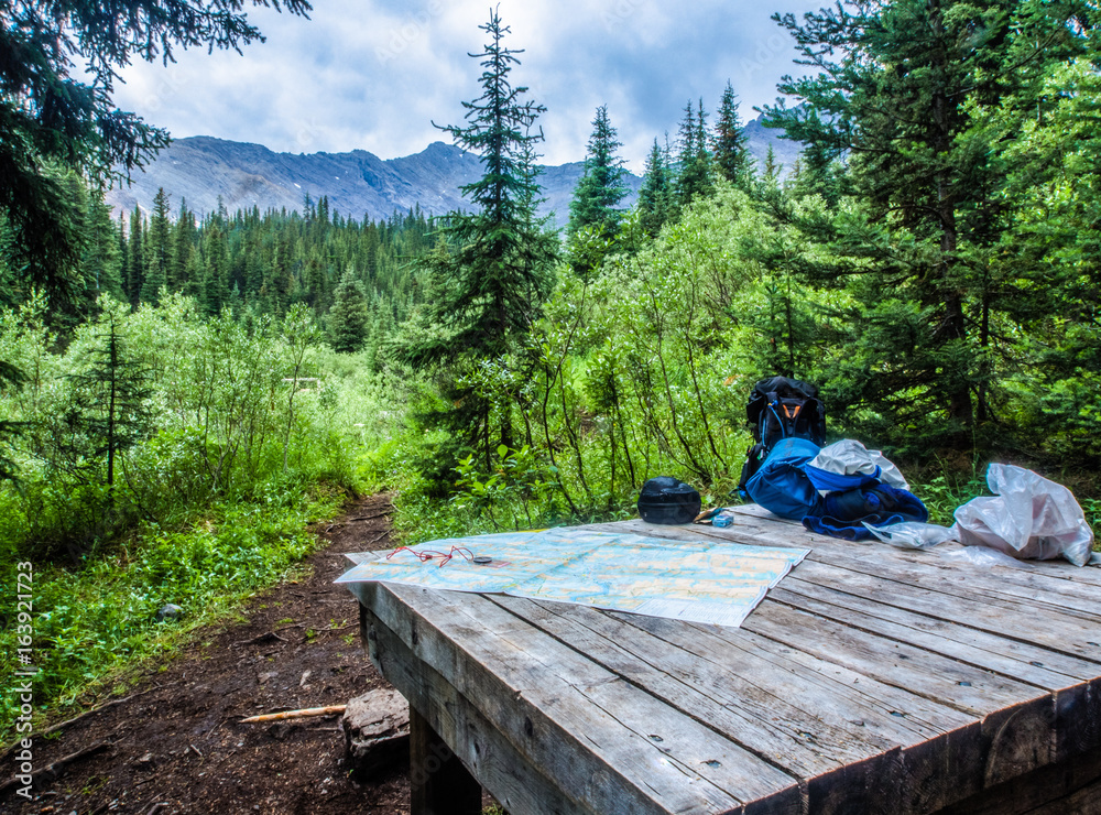 Planning a hike with a map on a picnic table in the backcountry of