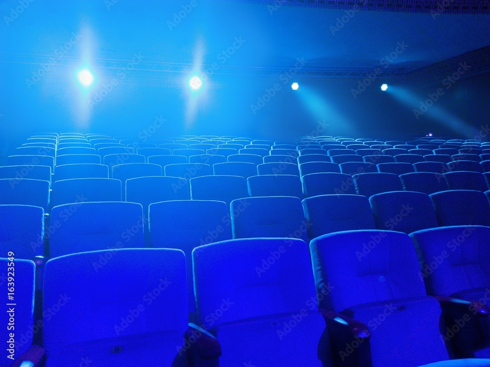 Naklejka premium Empty movie theater with projection light falling into the lens 
