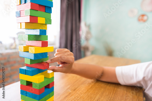 Close-up of asian woman's hand playing wood blocks stack game with copyspace, Learning and Education Background concept.