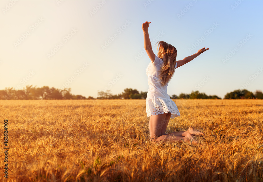 Beautiful young girl in white dress jumping in golden wheat Beautiful young girl in white dress jumping in golden wheat