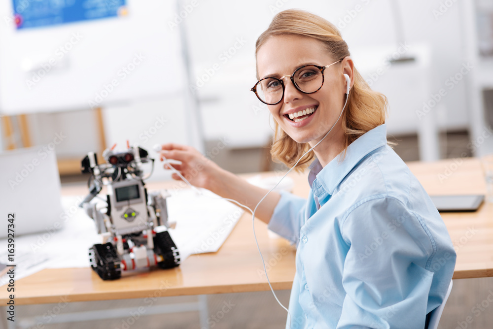Charismatic woman enjoying music with electronic robot indoors Charismatic woman enjoying music with electronic robot indoors