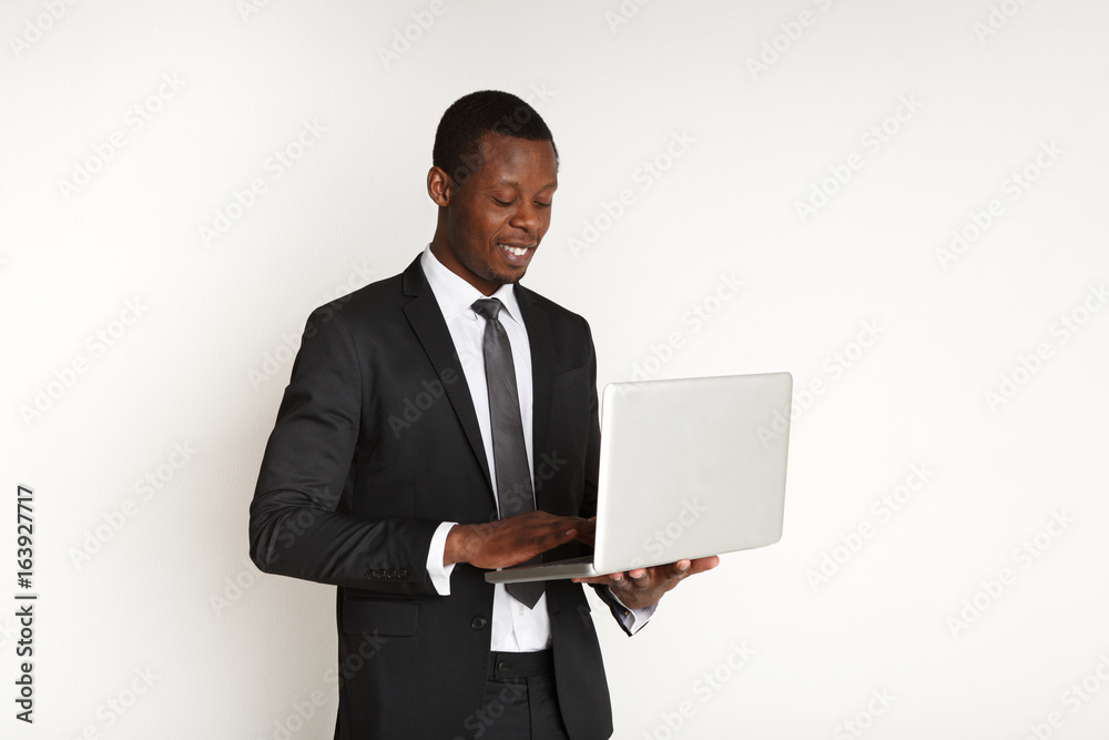 Smiling black businessman with laptop isolated Smiling black businessman with laptop isolated