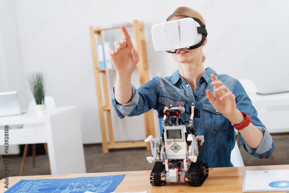 Inspired woman testing visual reality headset indoors Inspired woman testing visual reality headset indoors