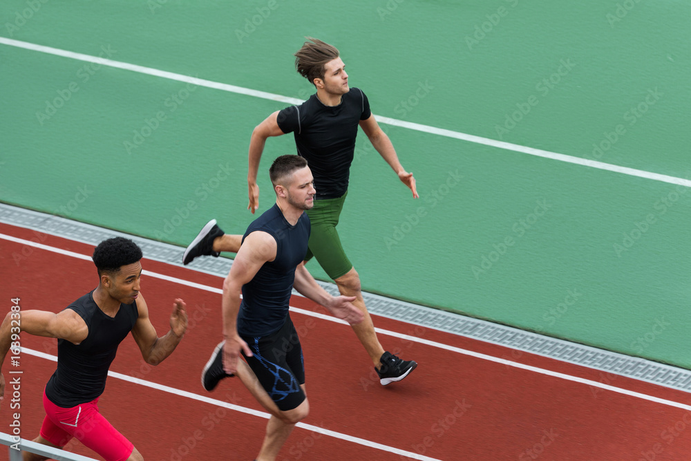 Handsome multiethnic athlete group run on running track