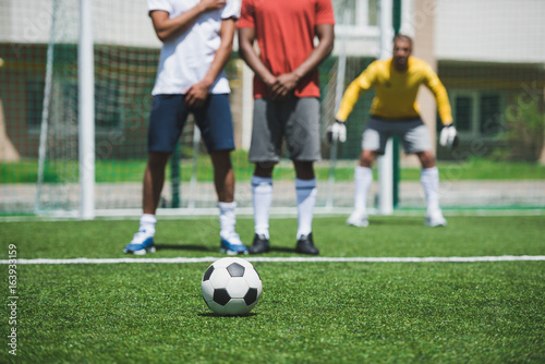 group of soccer players during soccer match on pitch, focus on foreground © LIGHTFIELD STUDIOS