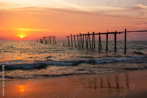 Evening light during sunset on the sea with an old wooden bridge.