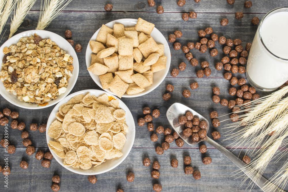 Various cold cereals on the dark wooden background.