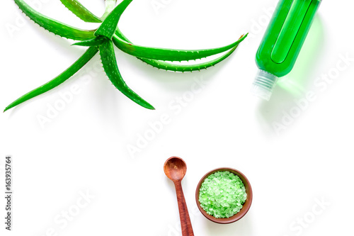 Aloe vera leafs, spa salt and cosmetic clean lotion on white background top view copyspace