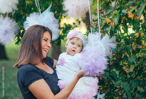 Beautiful mother and her little daughter outdoors. Nature. Beauty Mom and her child are playing in the park together. Mom and the child. photo